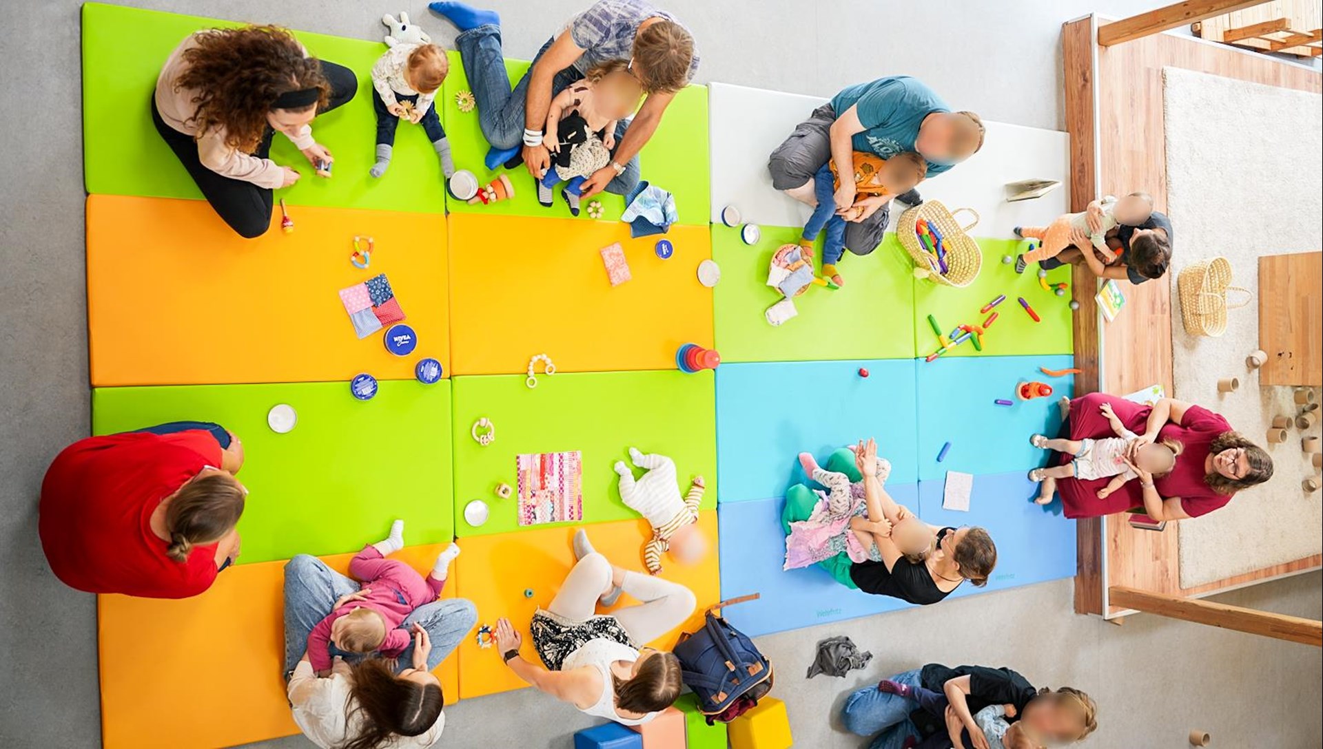 Zu sehen sind einige Eltern mit ihren Kindern bei der GemeinsamWachsen-Gruppe. 