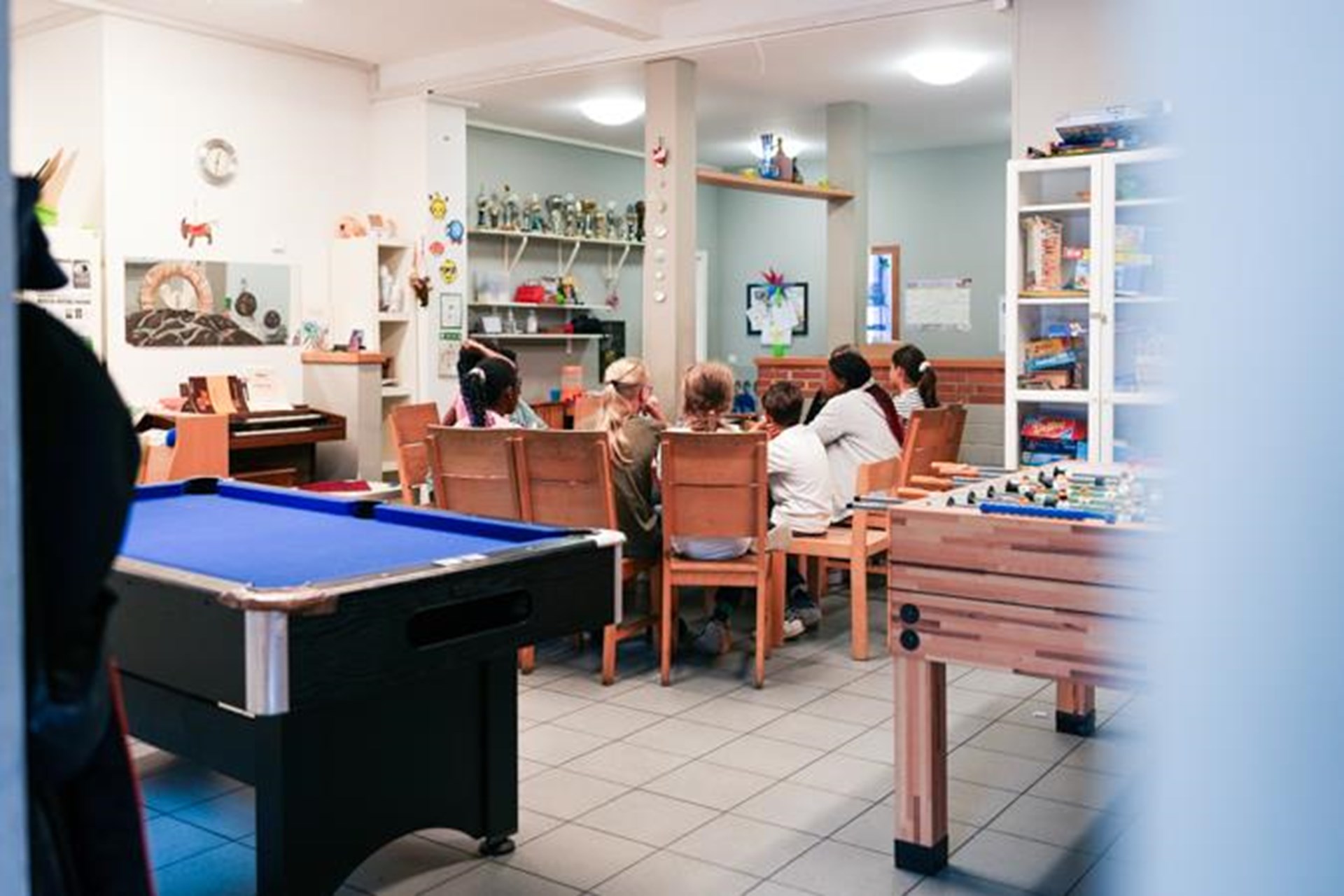Acht Kinder sitzen im Kinderzentrum am Mittagstisch.
